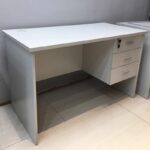 Create a productive workspace with the 1.2m Clerical Office Table. This practical office desk combines durability, functionality, and modern style. It is ideal for corporate offices, home offices, schools, and reception areas. The spacious 1.2-metre work surface provides plenty of room for a laptop, desktop computer, documents, and office accessories. As a result, you can keep your workspace organized and work more efficiently. Its clean and professional design also complements both modern and traditional office interiors. The table is made from high-quality engineered wood with a scratch-resistant finish. Therefore, it withstands everyday use while maintaining its attractive appearance. Additionally, the smooth surface is easy to clean, helping you keep your workspace looking professional. A sturdy metal frame and durable legs provide excellent strength and stability. Consequently, the desk remains secure even during daily use. The generous legroom also promotes comfort throughout the workday. Whether you are completing paperwork, attending virtual meetings, or studying, this office table provides a dependable workspace. Furthermore, its compact size makes it suitable for small and medium-sized offices without reducing your available work area. The minimalist design allows the desk to pair easily with different office chairs and storage cabinets. Moreover, it blends seamlessly into a wide range of office settings. This flexibility makes it a smart choice for businesses and home offices alike. The desk is also quick to assemble and requires very little maintenance. Finally, its durable construction ensures long-lasting performance, giving you excellent value for your investment. Key Features: Spacious 1.2-metre work surface Strong and durable construction Scratch-resistant and easy-to-clean desktop Stable metal frame and sturdy legs Modern and professional design Comfortable legroom for improved productivity Suitable for offices, home offices, schools, and reception areas Easy to assemble and maintain